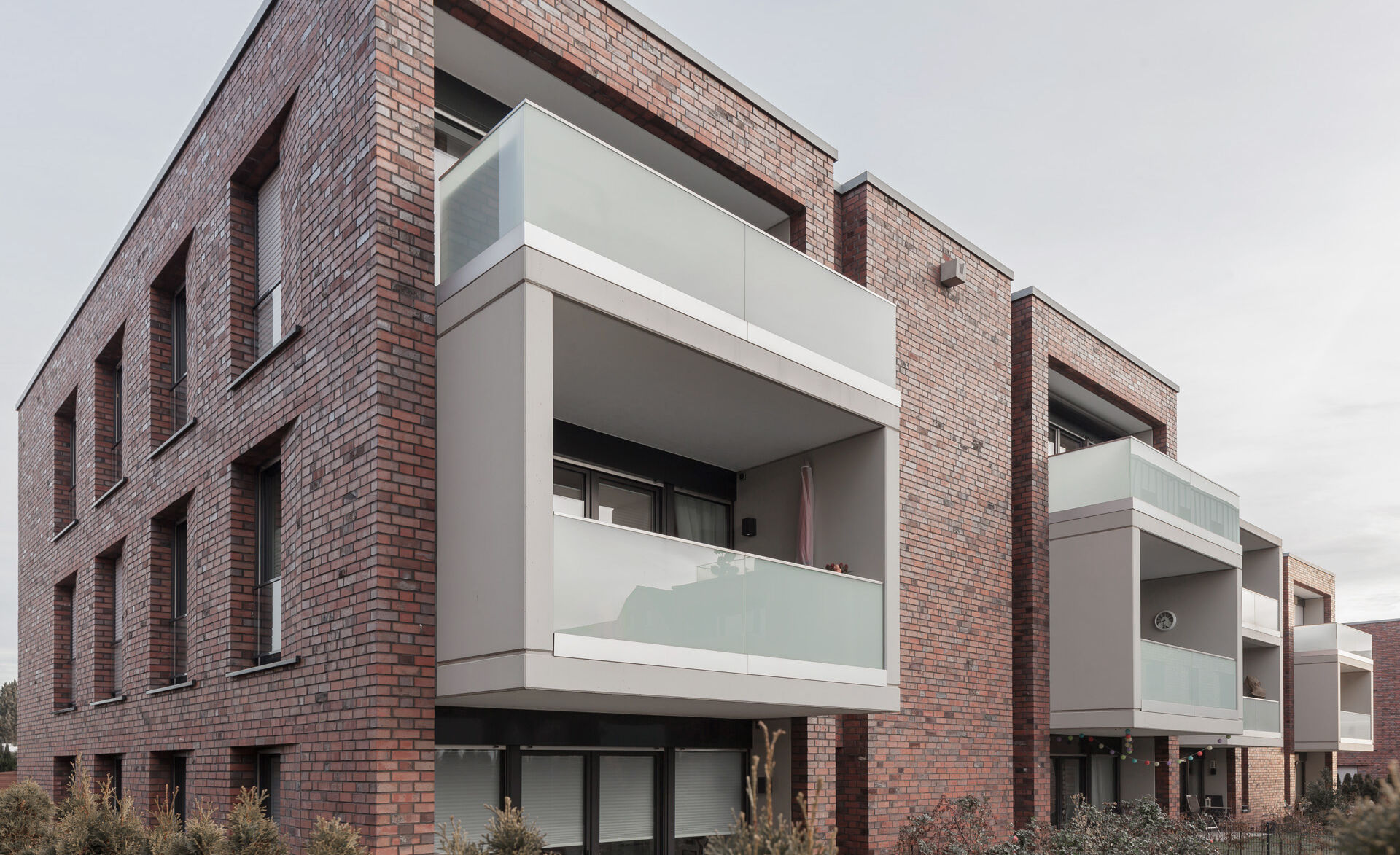 Glas und Backstein harmonieren bei diesen Balkonen perfekt: Glasgeländer von Glas Marte