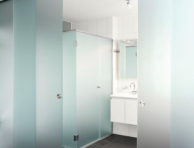 GM Toproll 100 Badezimmer Badezimmer mit einer halbtransparenten Schiebetür aus Glas.