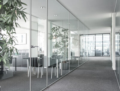 GM Martition Light Glas Marte Moderner Büroraum mit großen Glaswänden, die Besprechungsräume von einem Flur abtrennen.