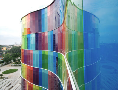 Geschwungene Glasfassade aus farbigem VSG