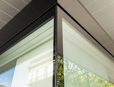 Uniglas Glassic U Nahaufnahme einer Gebäudeecke mit großen, reflektierenden Glasfassaden.