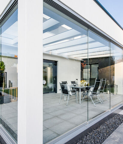 Terrasse eines Einfamilienhauses mit raumhohen Glas-Schiebetüren